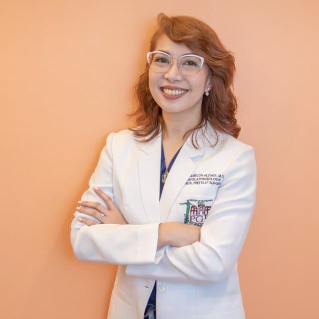 Dr. Jennifer Almelor-Alzaga, ENT and head and neck surgeon, smiling with arms crossed in a white coat